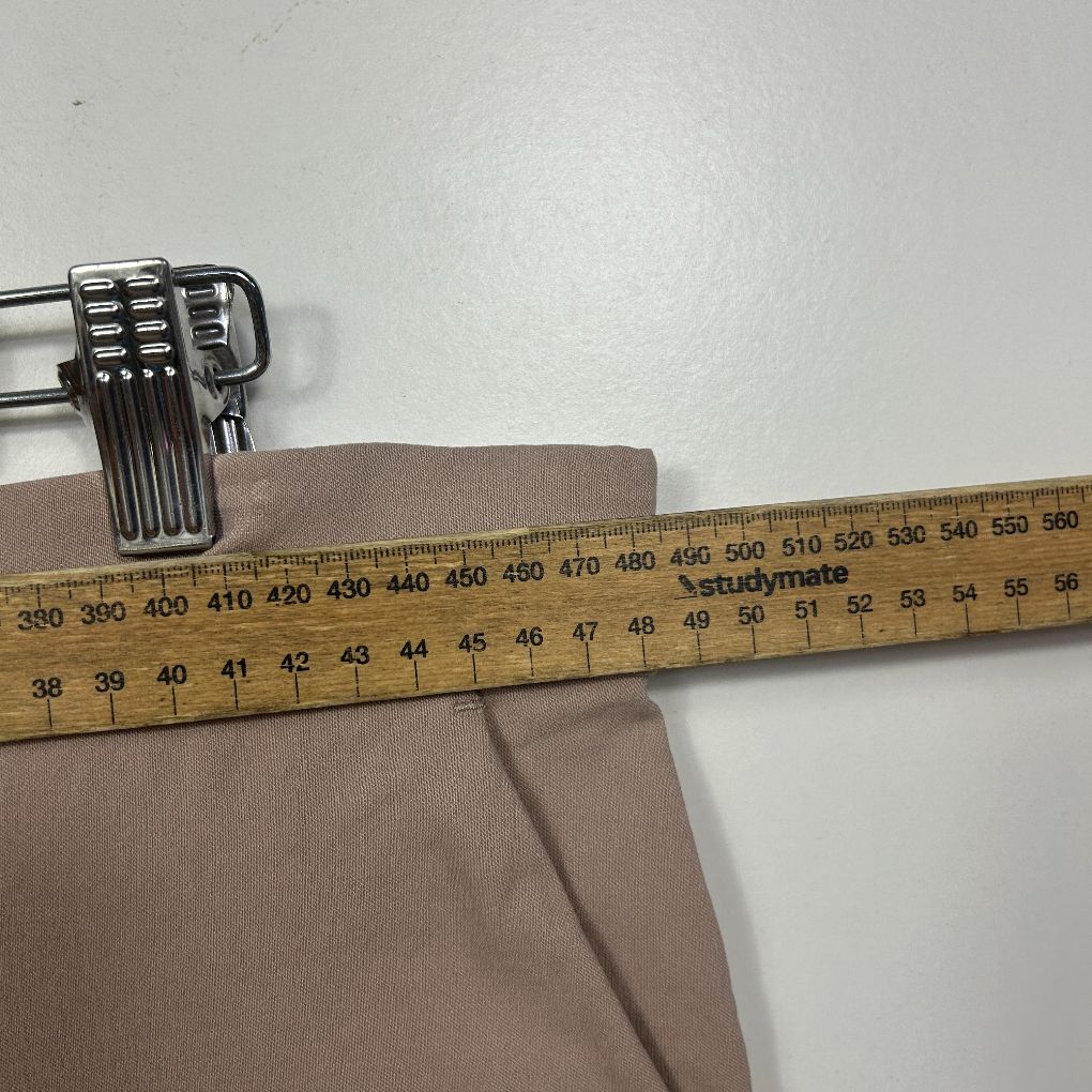 Beige pants waistband detail view with measuring tape