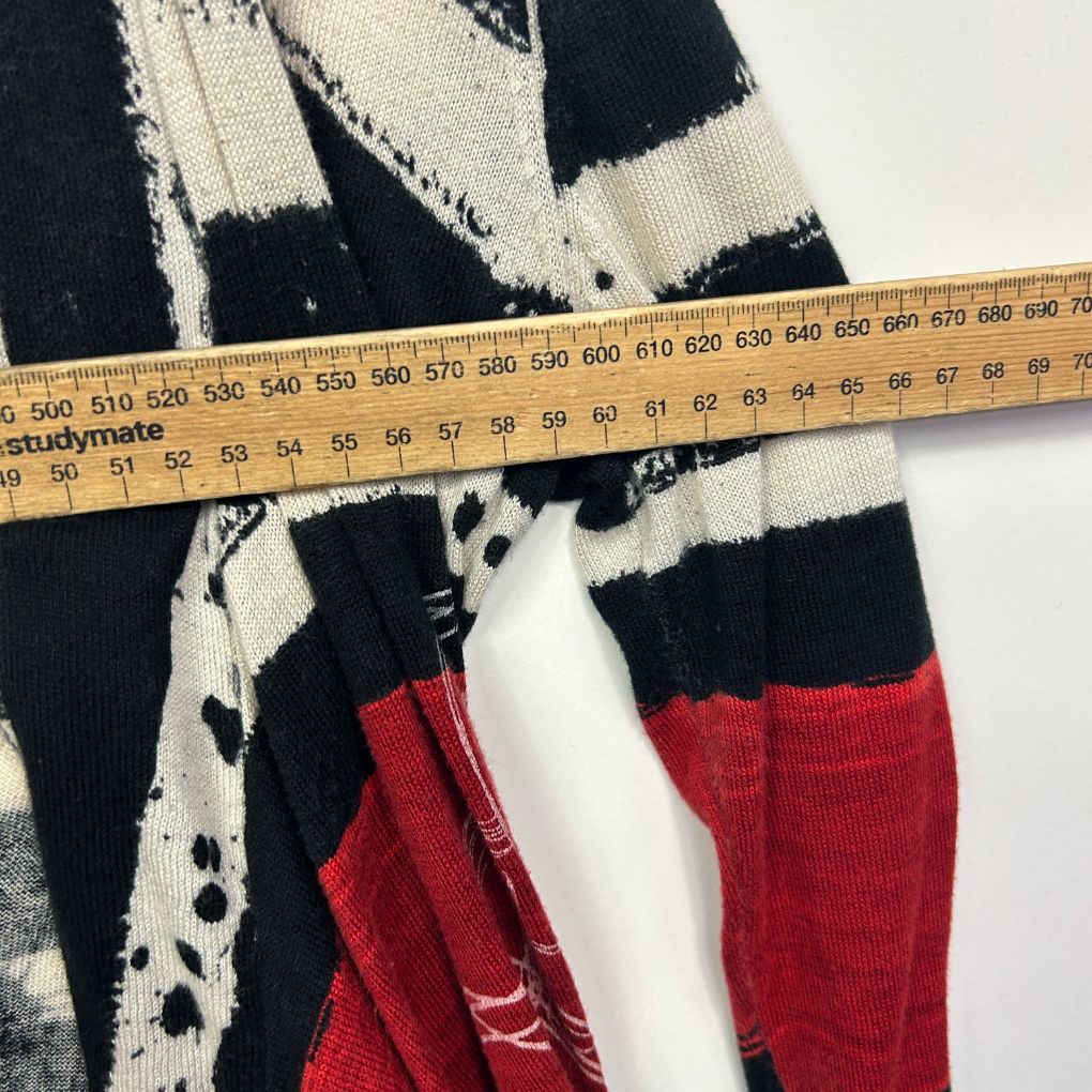 Black white and red geometric patterned sweater detail view with measuring tape