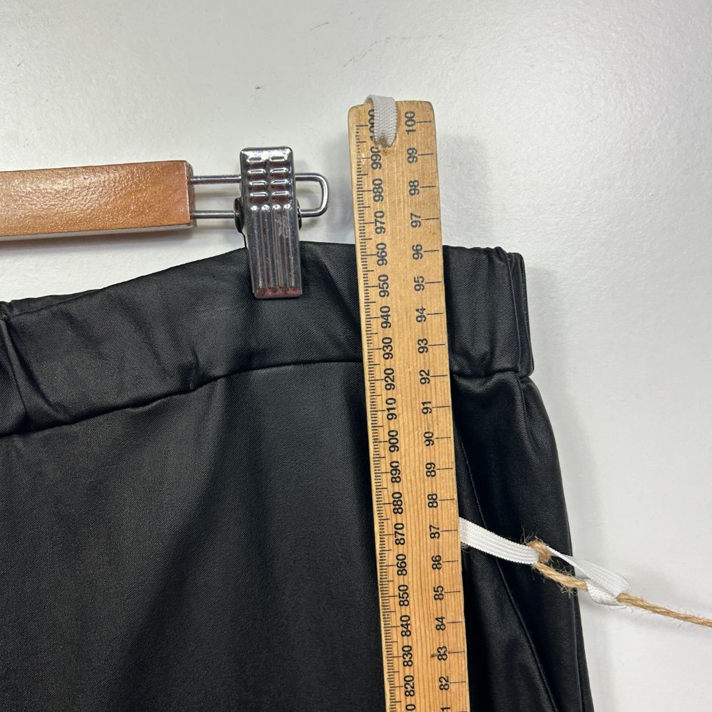 Black pants detail view with measuring tape