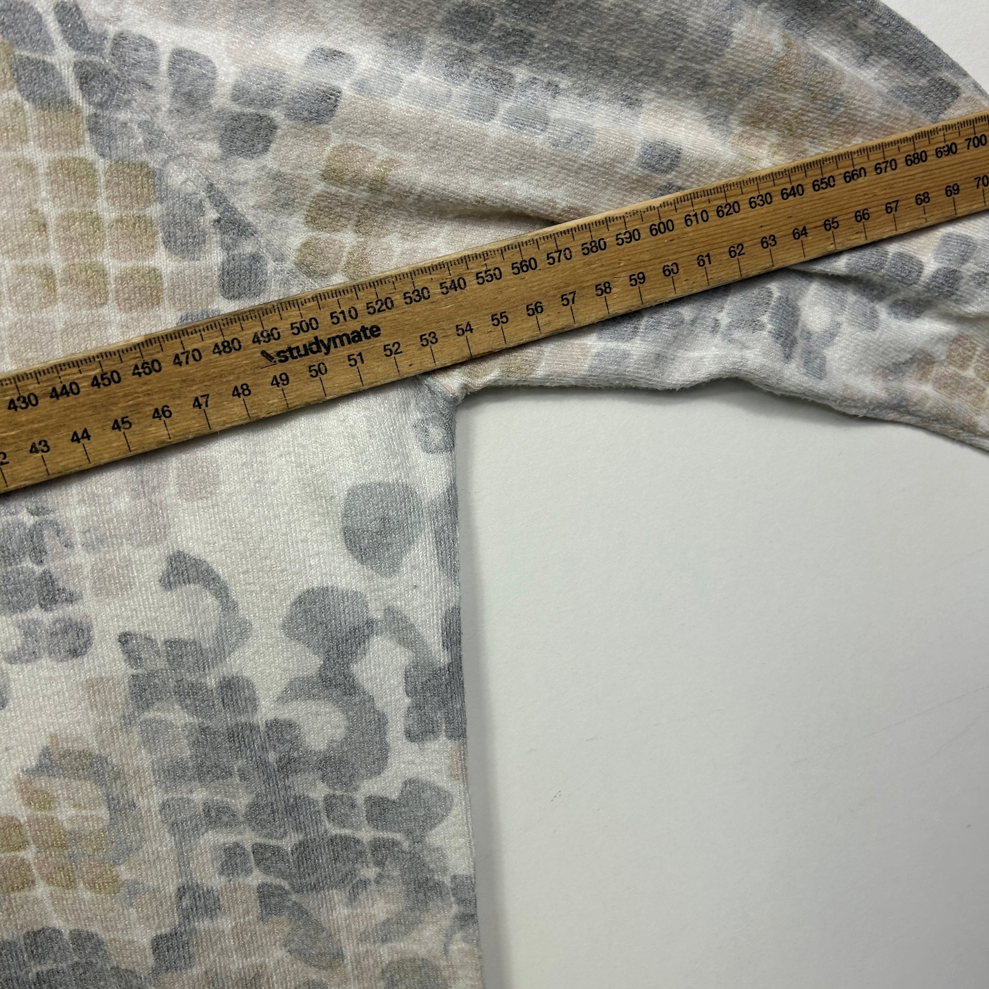 Grey and white patterned fabric detail view with measuring tape