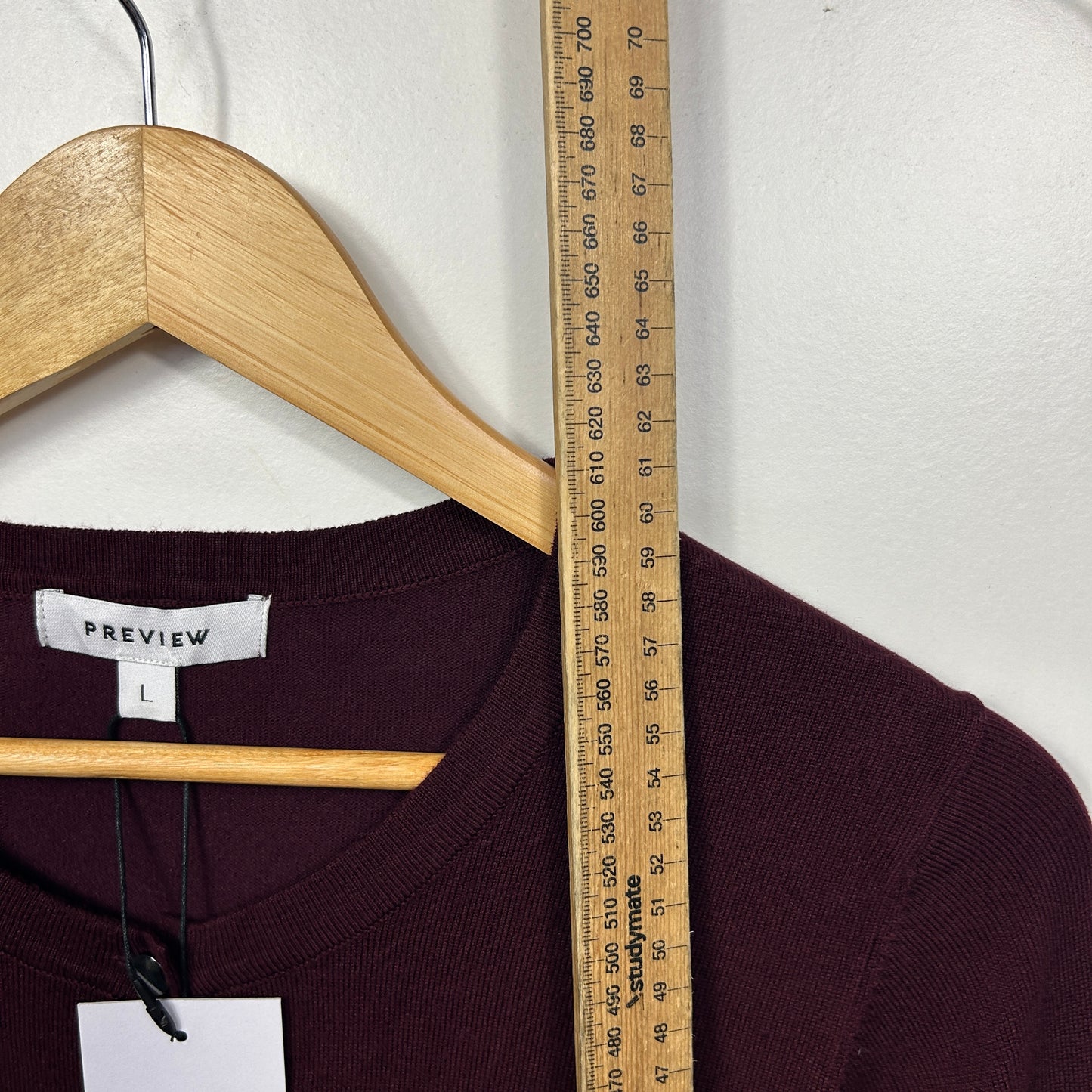 Black ribbed top front view with wooden hanger and measuring tape