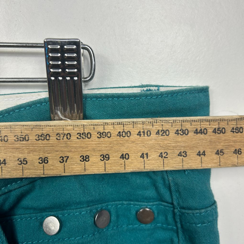 Teal pants waistband detail view with measuring tape