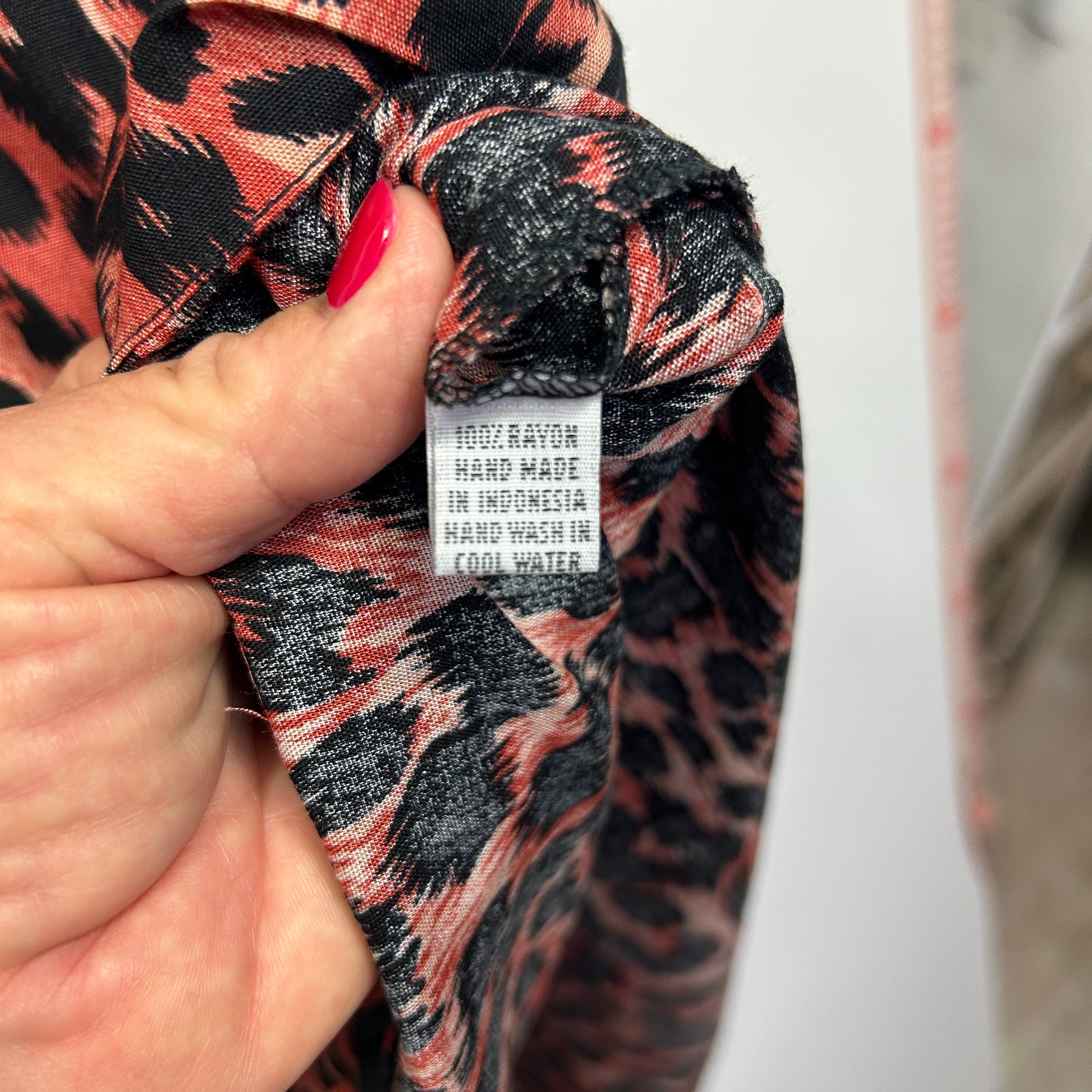 Red and black patterned garment detail view showing label