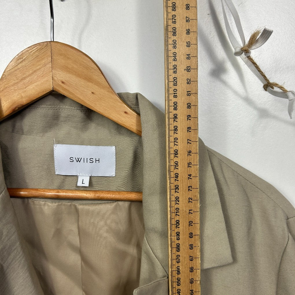 Beige trench coat front view on wooden hanger with measuring tape