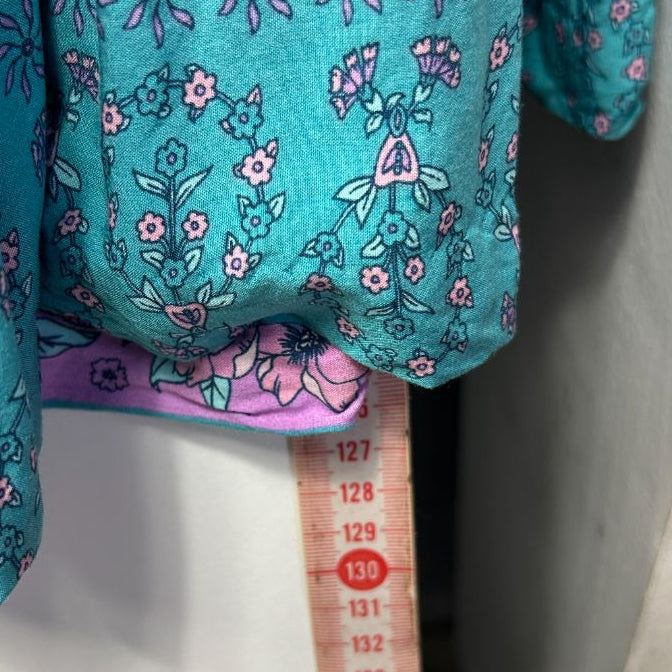 Turquoise floral dress with measurement tape detail view