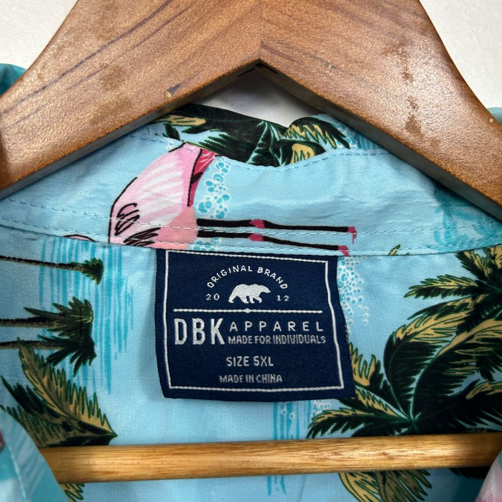 Light blue shirt with tropical palm leaf print on wooden hanger detail view