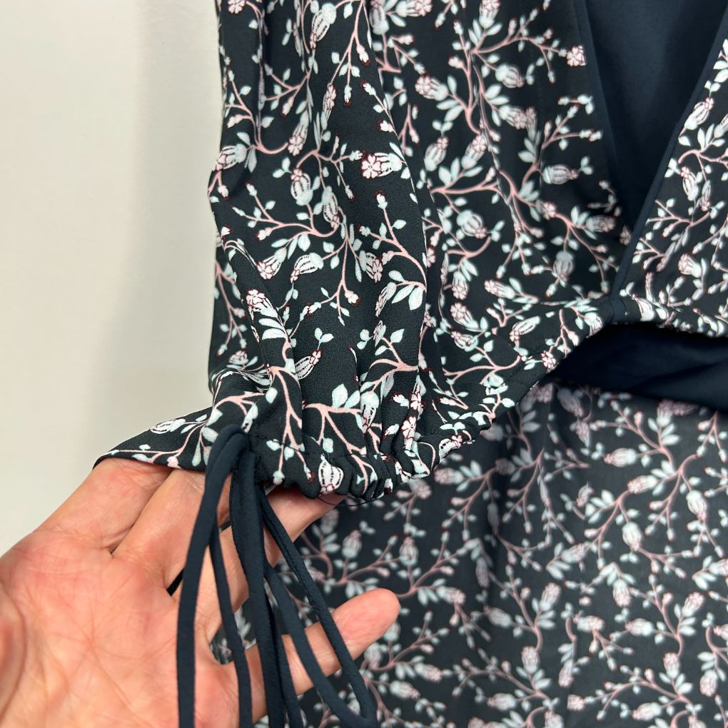 Black and white floral shirt detail view showing sleeve and tie closure
