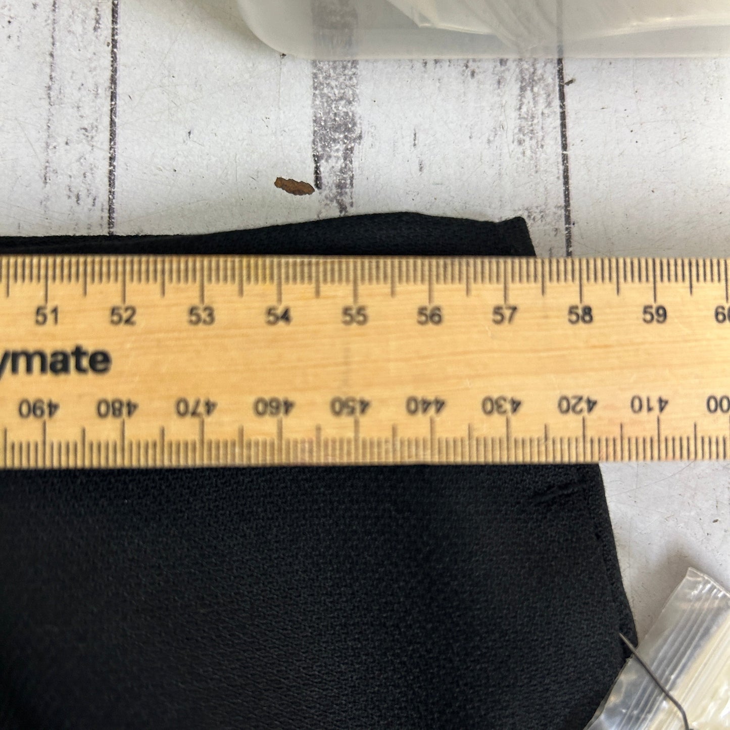 Black fabric detail view with measuring ruler