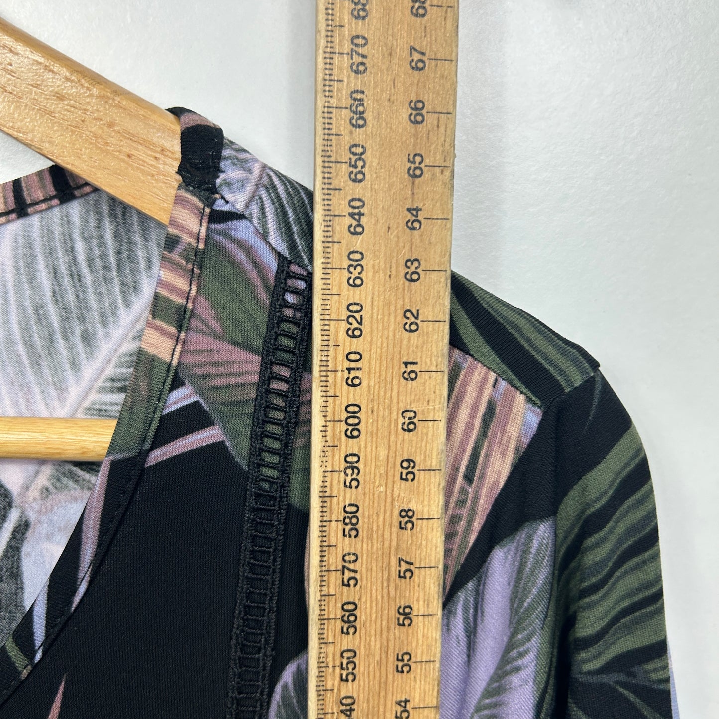 Black striped jacket detail view with measuring tape