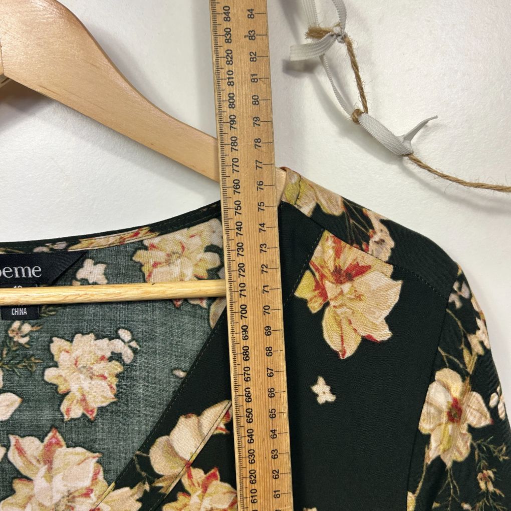Black floral top detail view with measuring tape