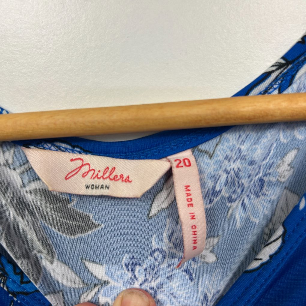 Blue floral dress label and wooden hanger detail view