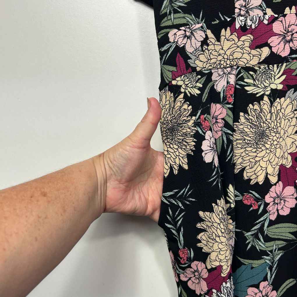 Black floral dress detail view showing fabric texture