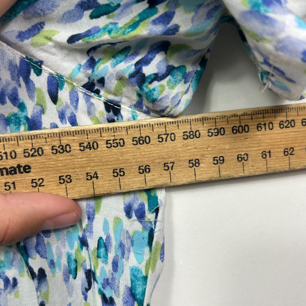 Blue green and white floral fabric detail view with measuring tape