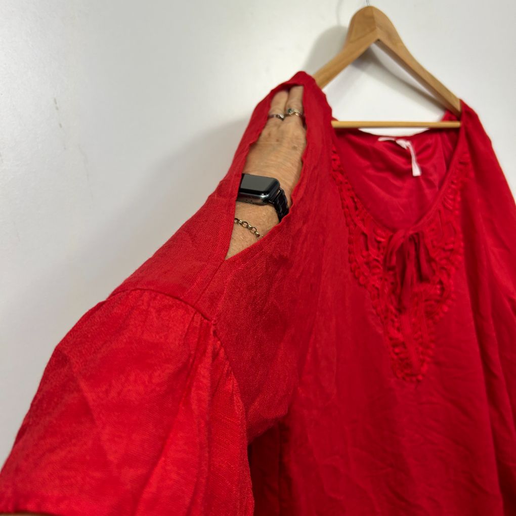Red long sleeve top front view on hanger