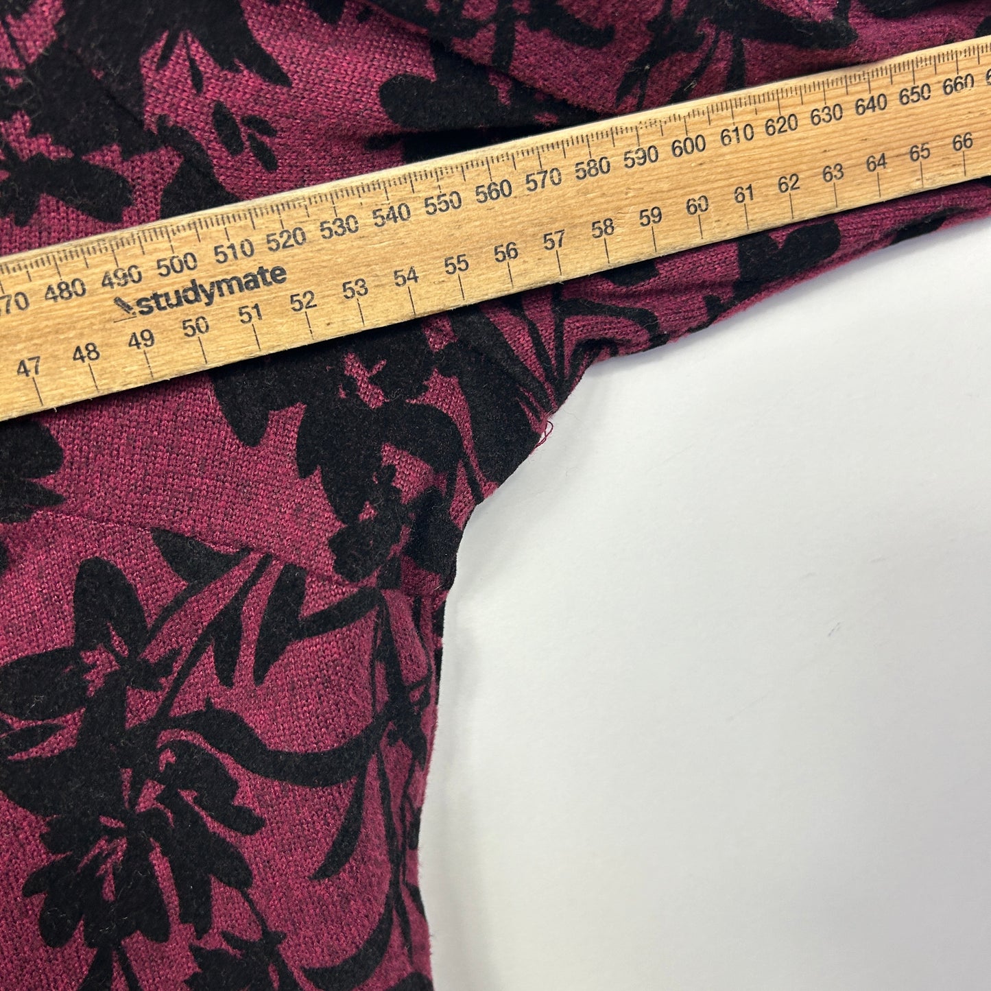 Pink and black floral fabric with measuring tape detail view