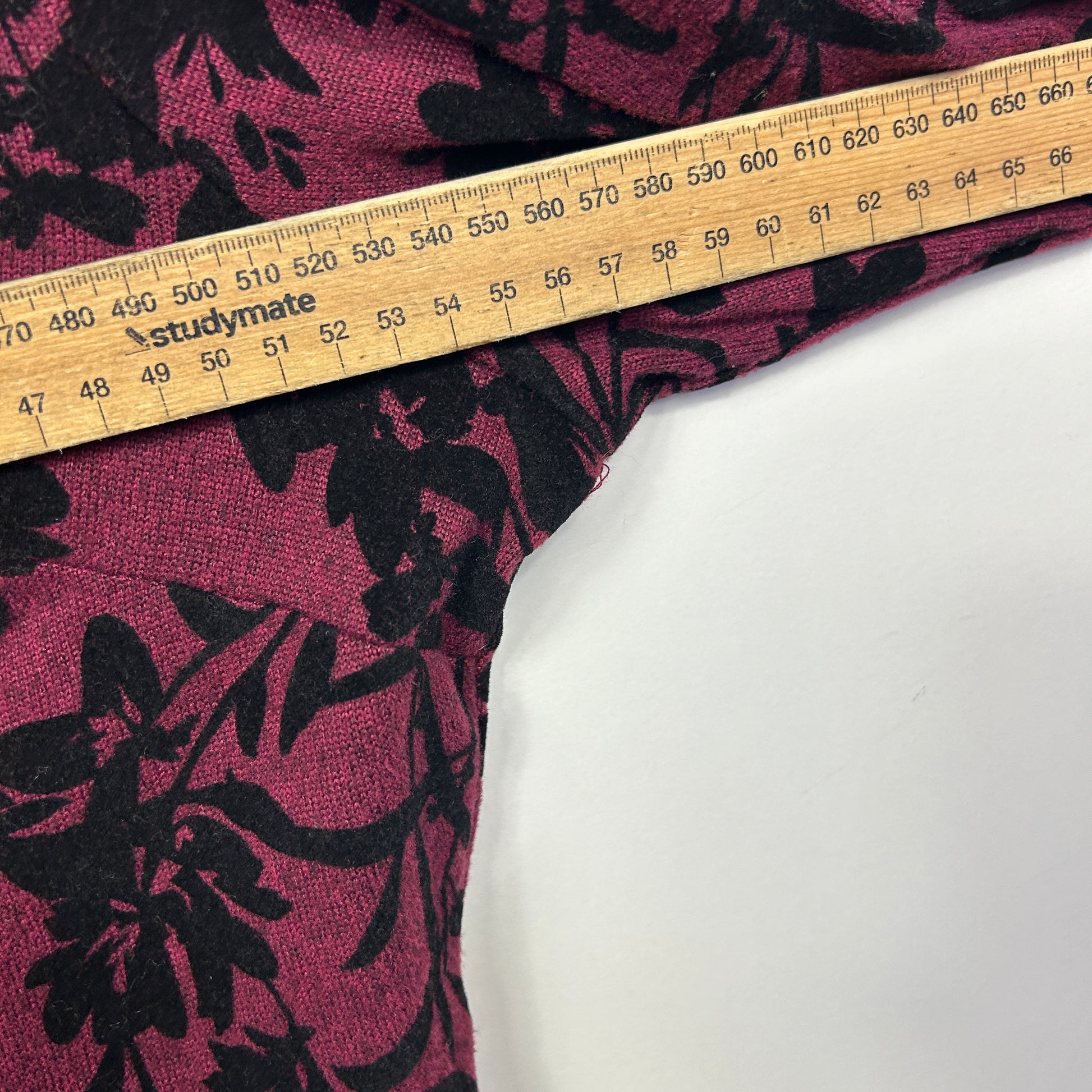Pink and black floral fabric with measuring tape detail view