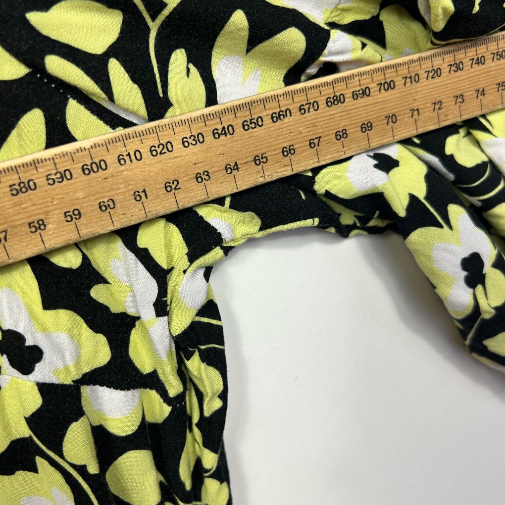 Yellow and black floral fabric detail view with measuring tape