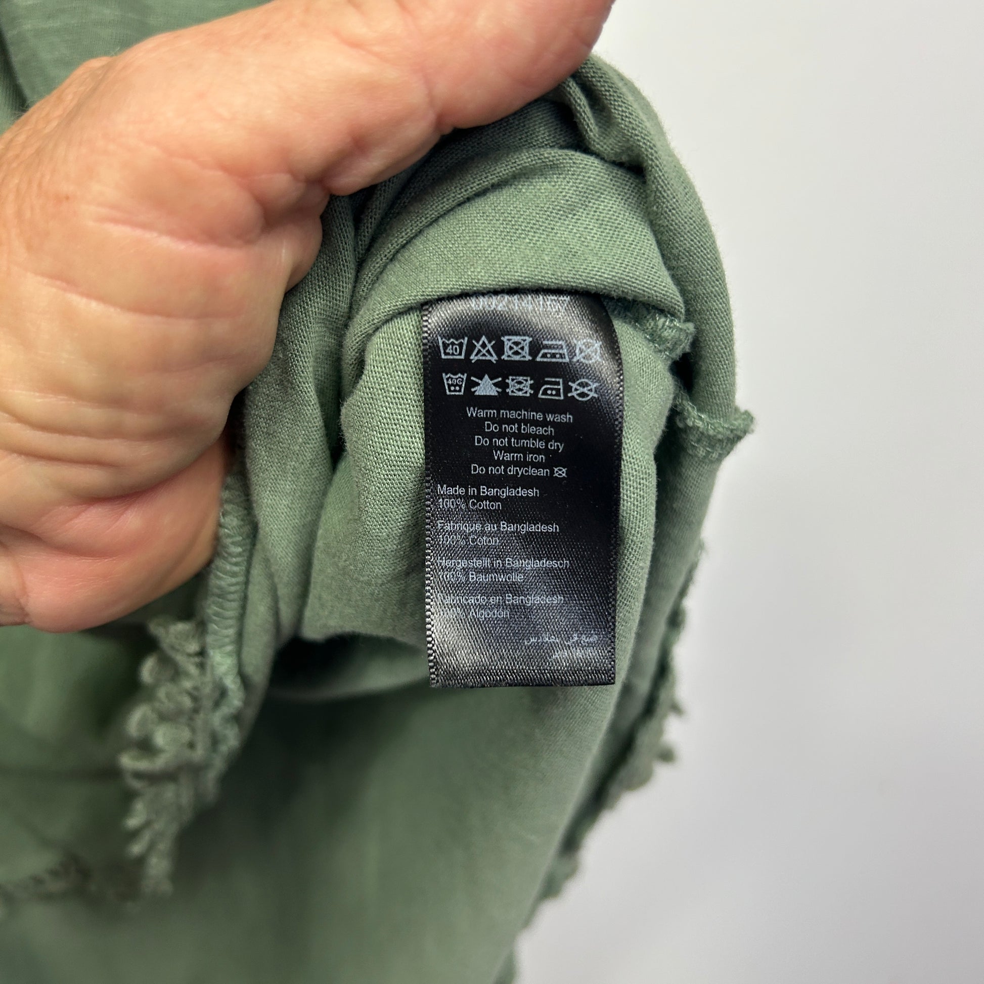 Sage green garment label detail view
