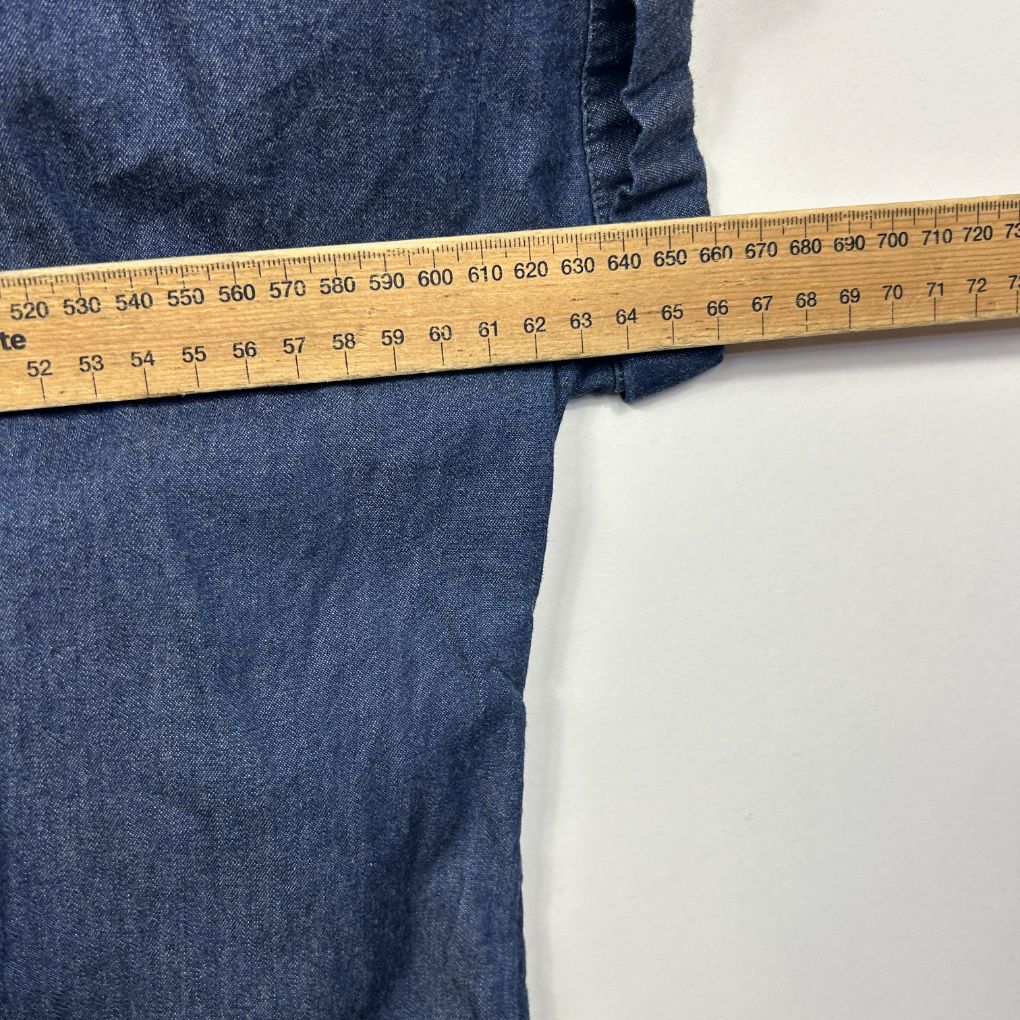 Blue denim garment with measuring tape detail view