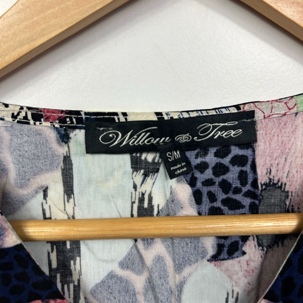 Willow Tree brand clothing label detail view showing black tag with multicolored geometric and animal print fabric