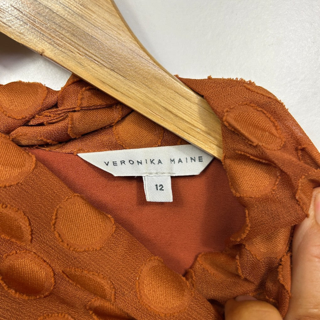Rust brown top with polka dot pattern label view