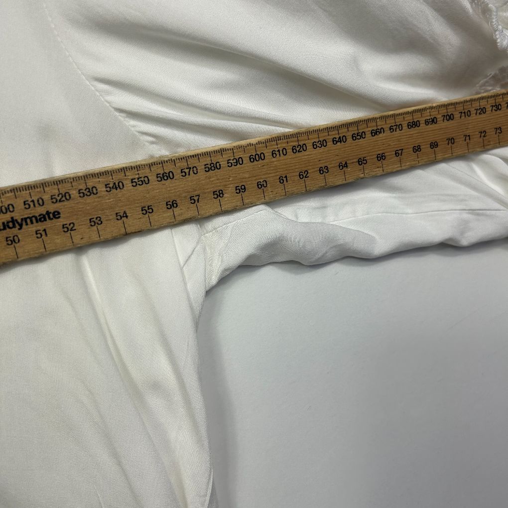 White fabric detail view with measurement tape