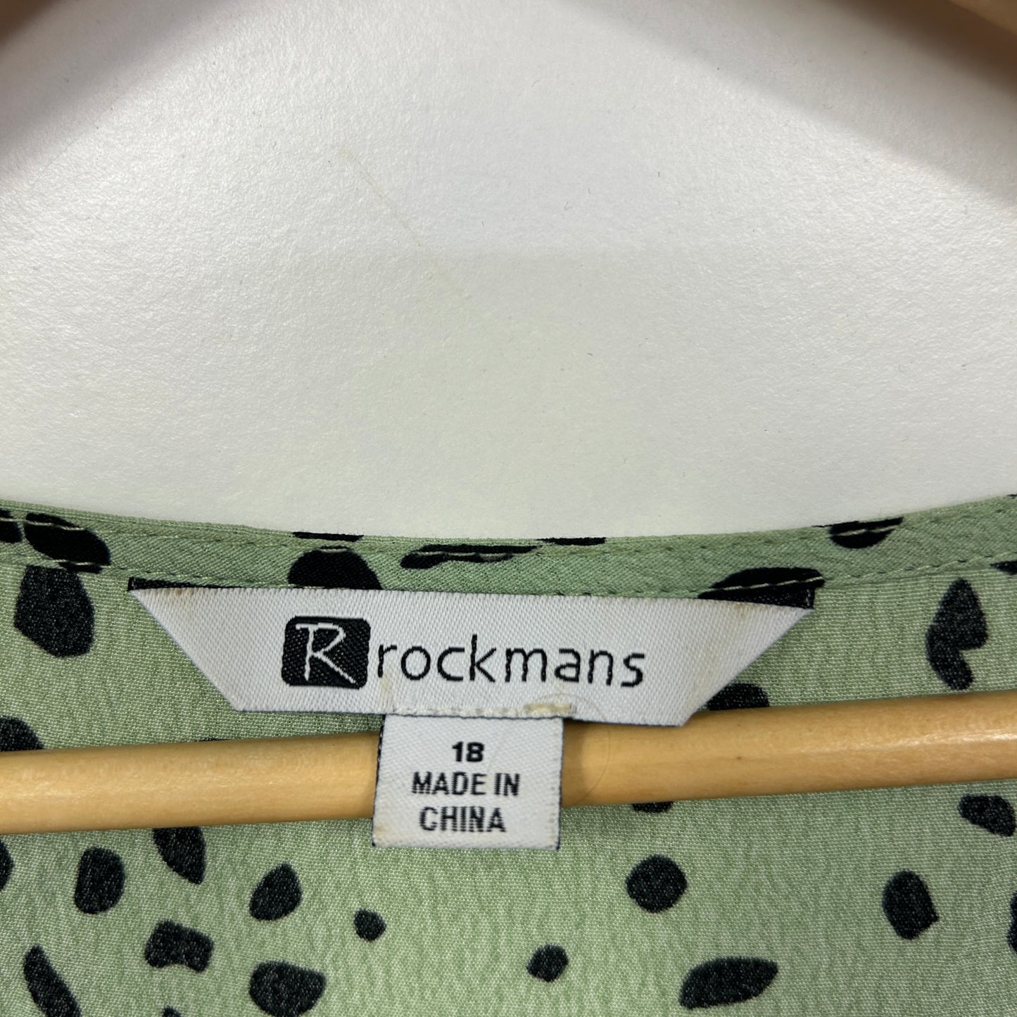 Green cardigan with black spot pattern label view
