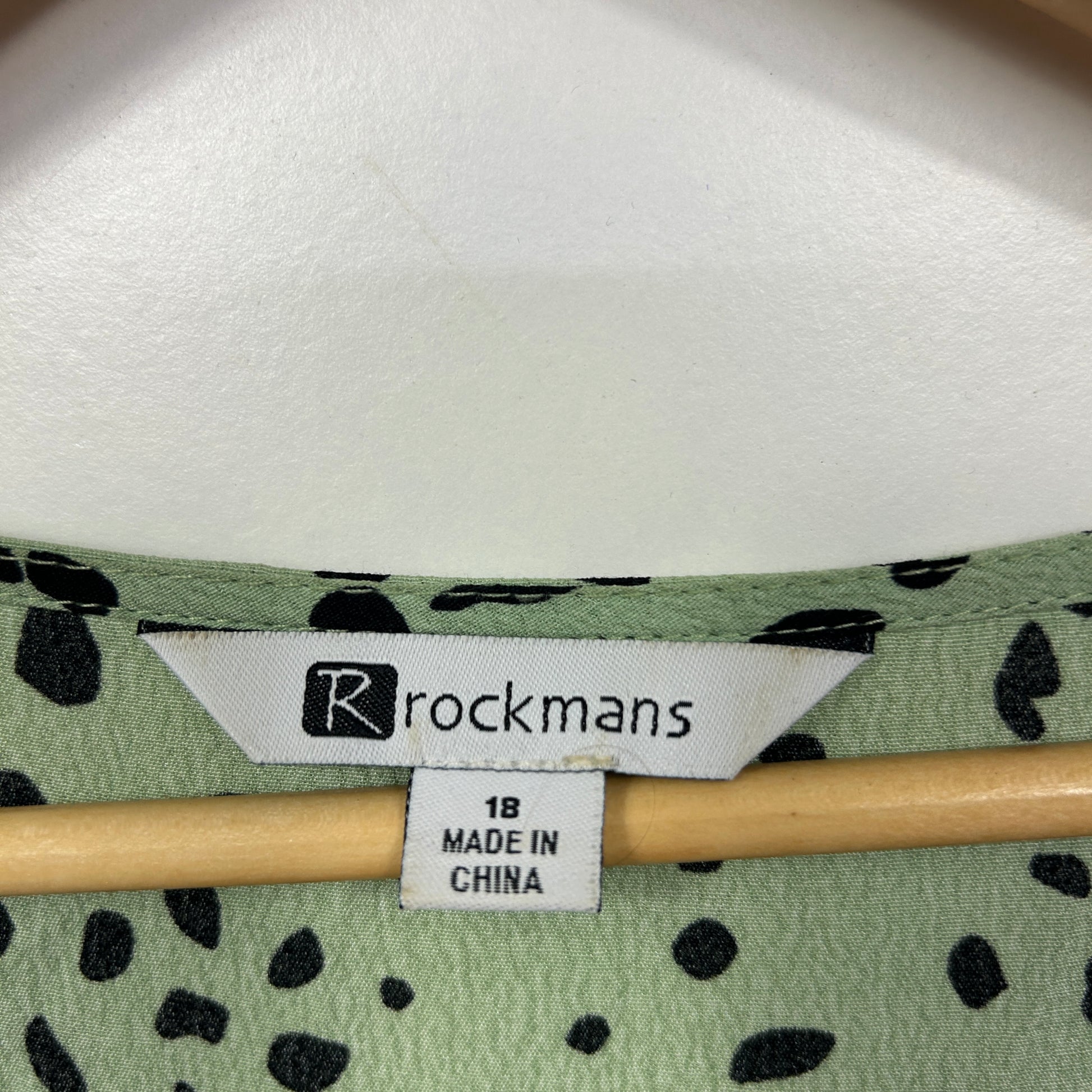 Green cardigan with black spot pattern label view
