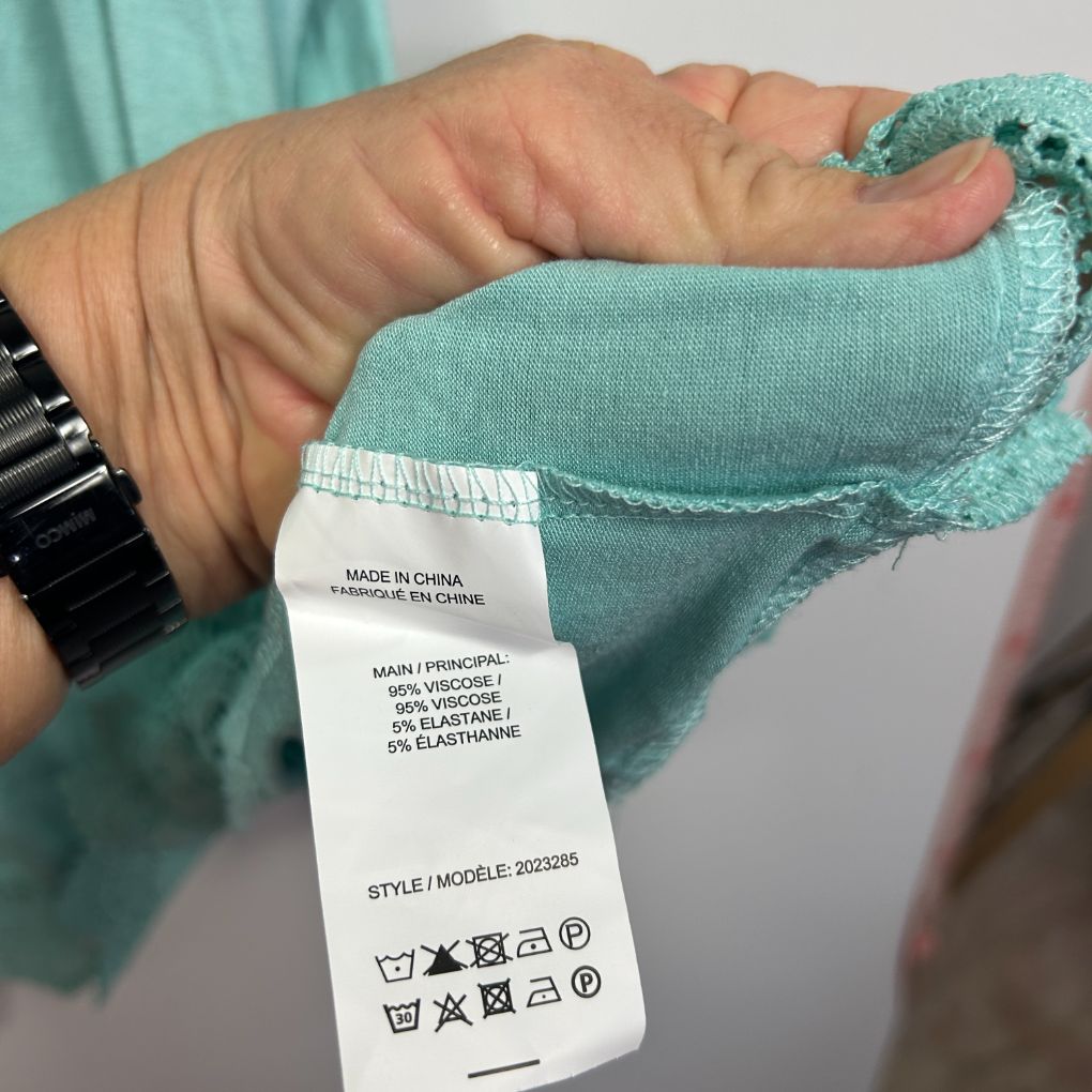 Teal sweater label detail view