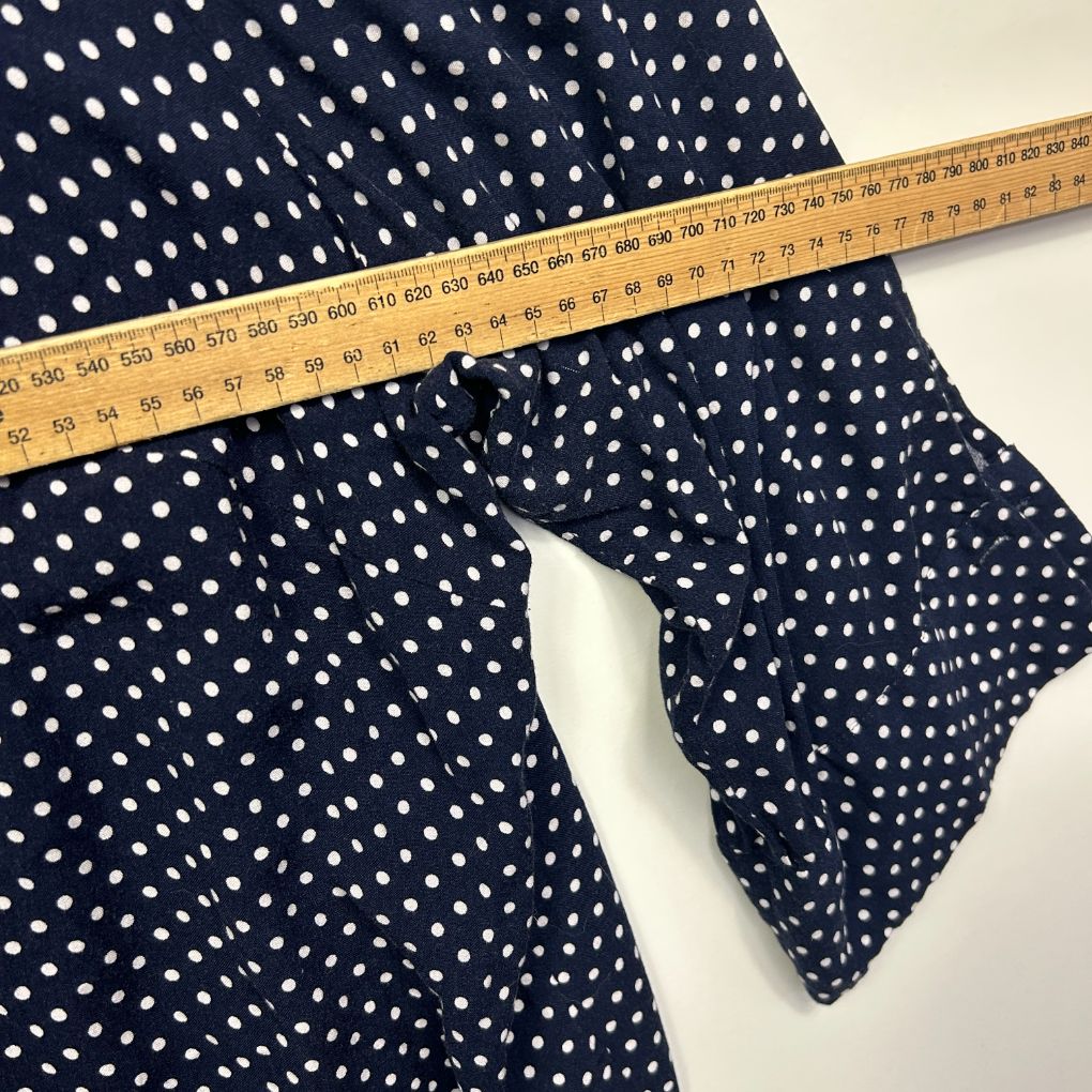 Navy polka dot fabric with measuring tape detail view