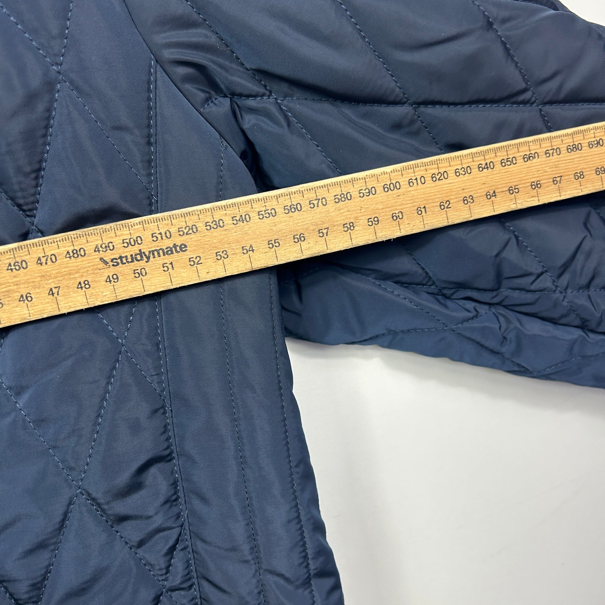 Navy quilted jacket sleeve measured with tape detail view