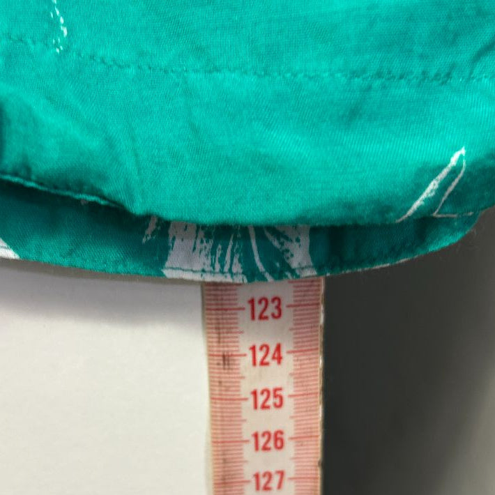 Turquoise garment detail view with measuring tape
