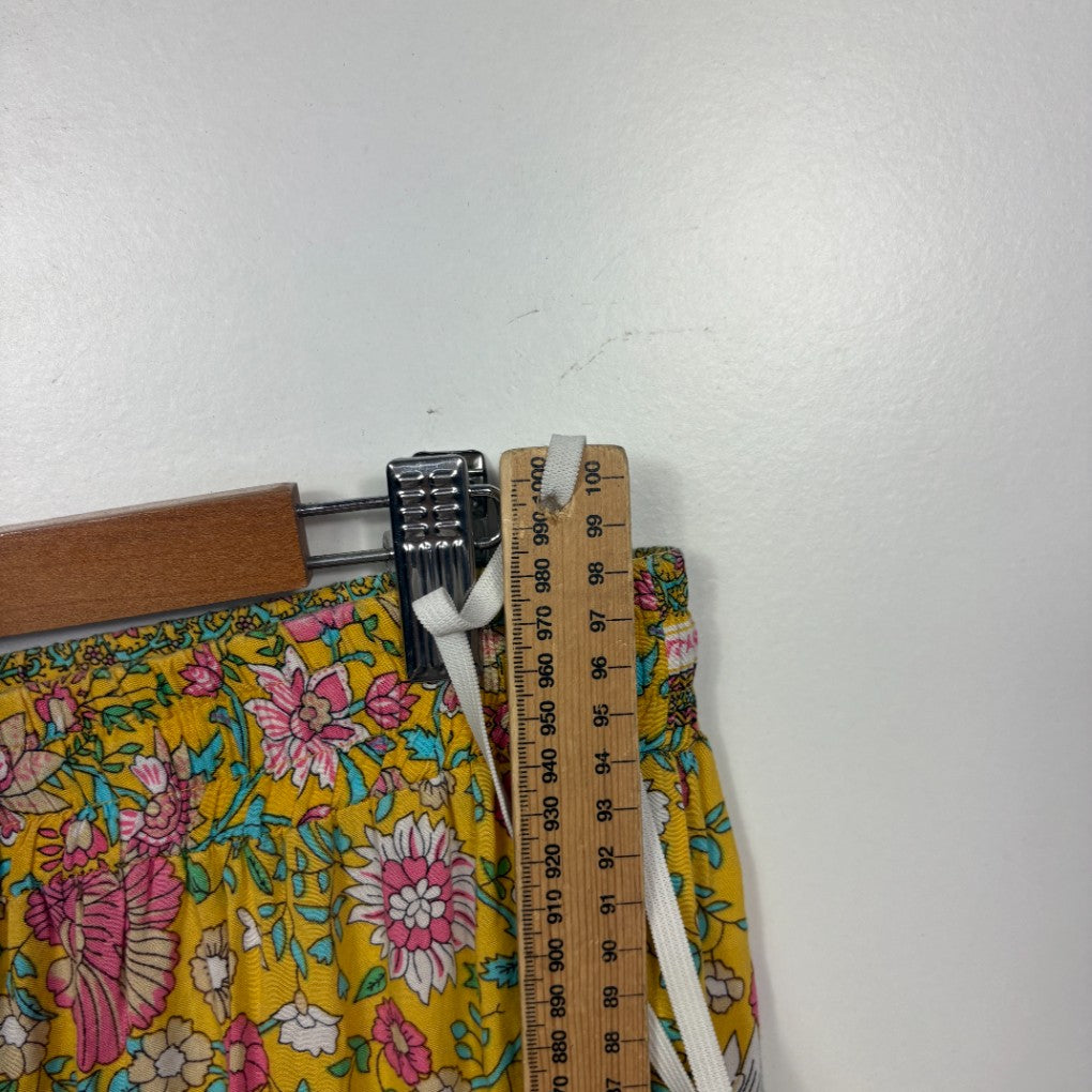 Yellow floral pants detail view with measuring tape