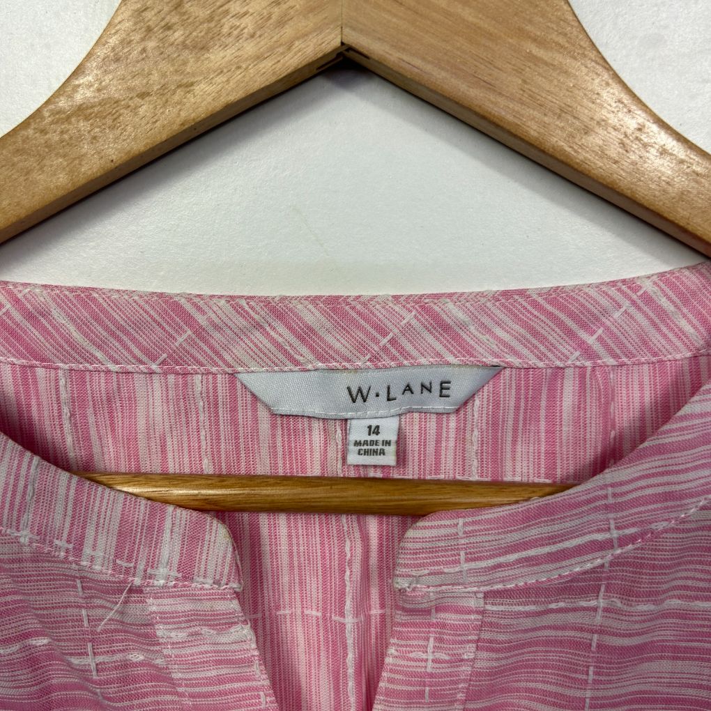 Pink striped shirt detail view on wooden hanger