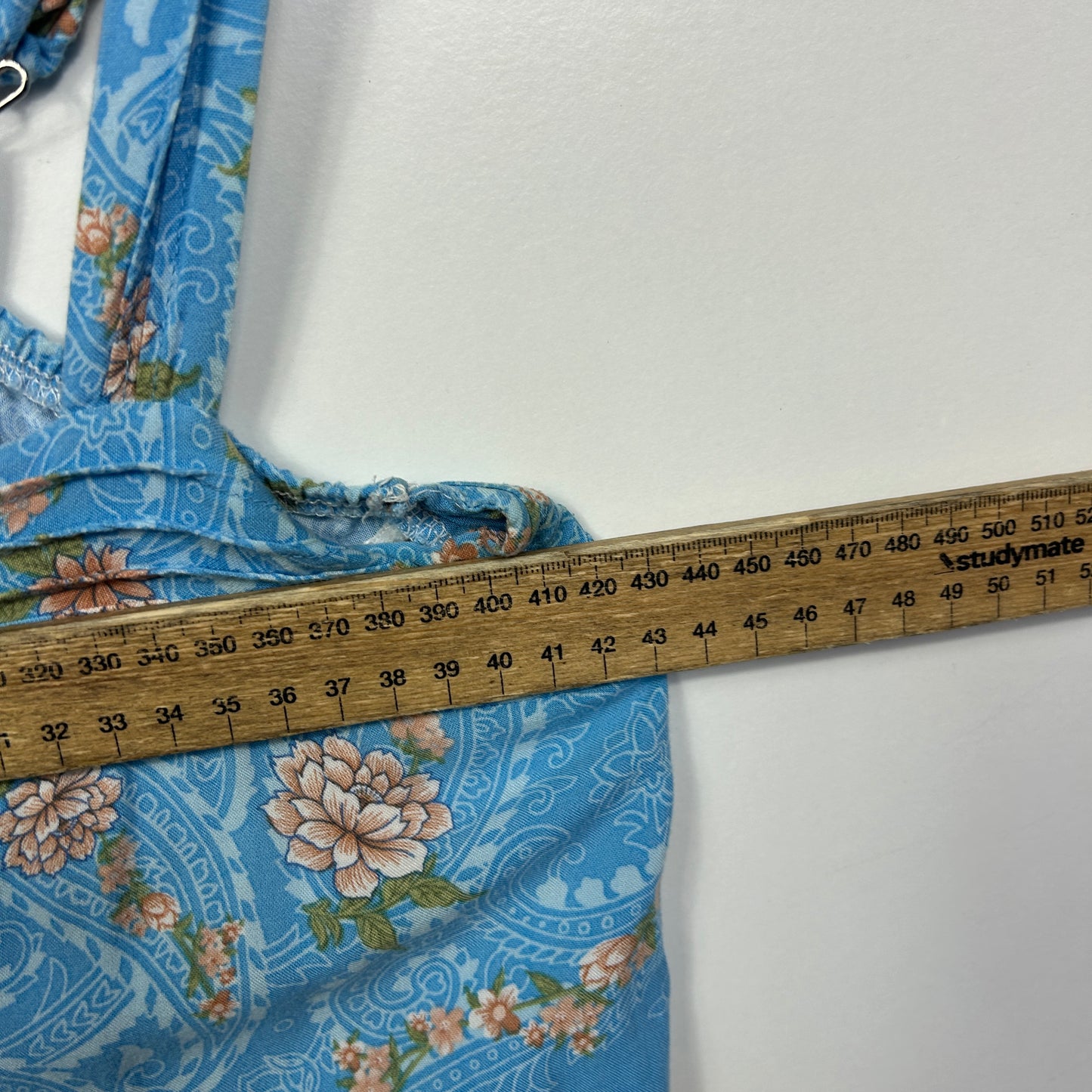 Blue floral denim jacket detail view with measuring tape