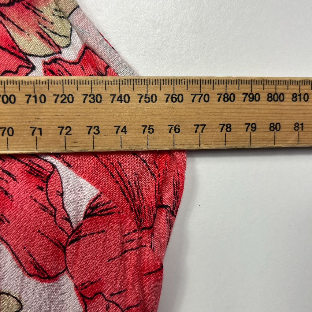 Red floral fabric detail view with measuring ruler