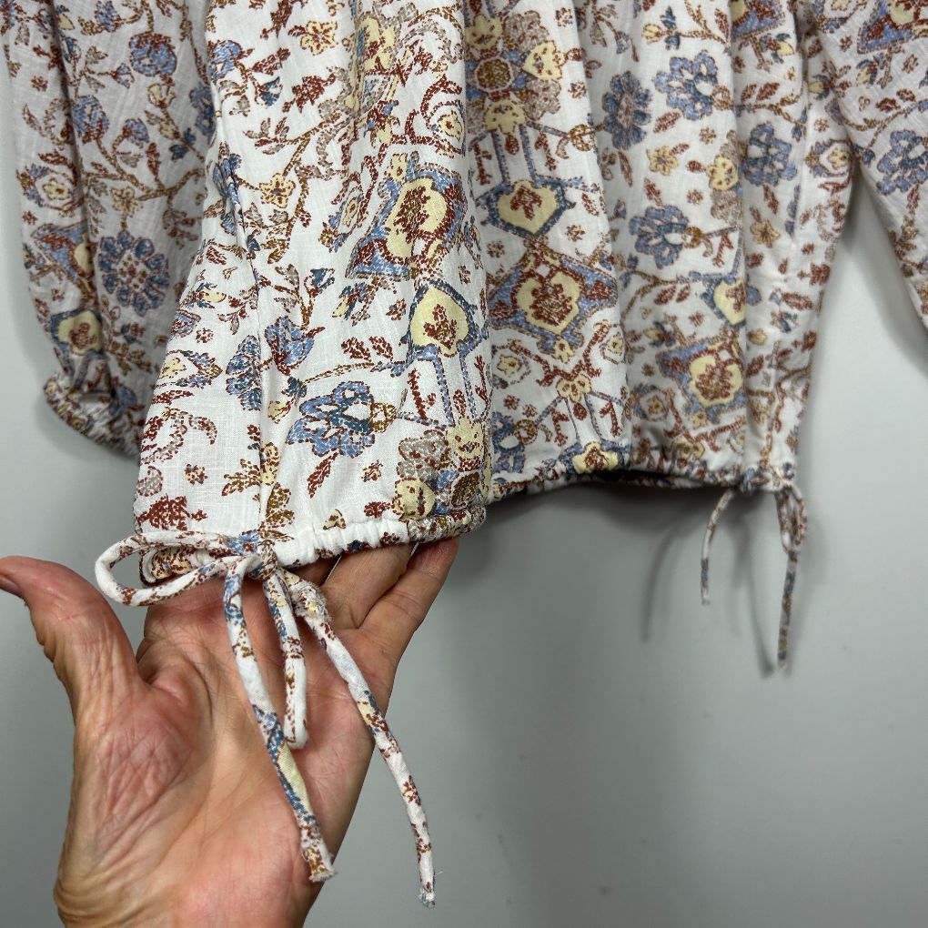 Cream floral long sleeve top detail view showing drawstring cuff