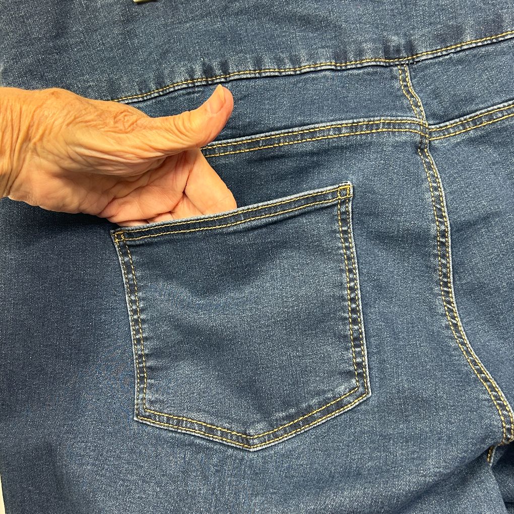 Blue denim jeans back pocket detail view