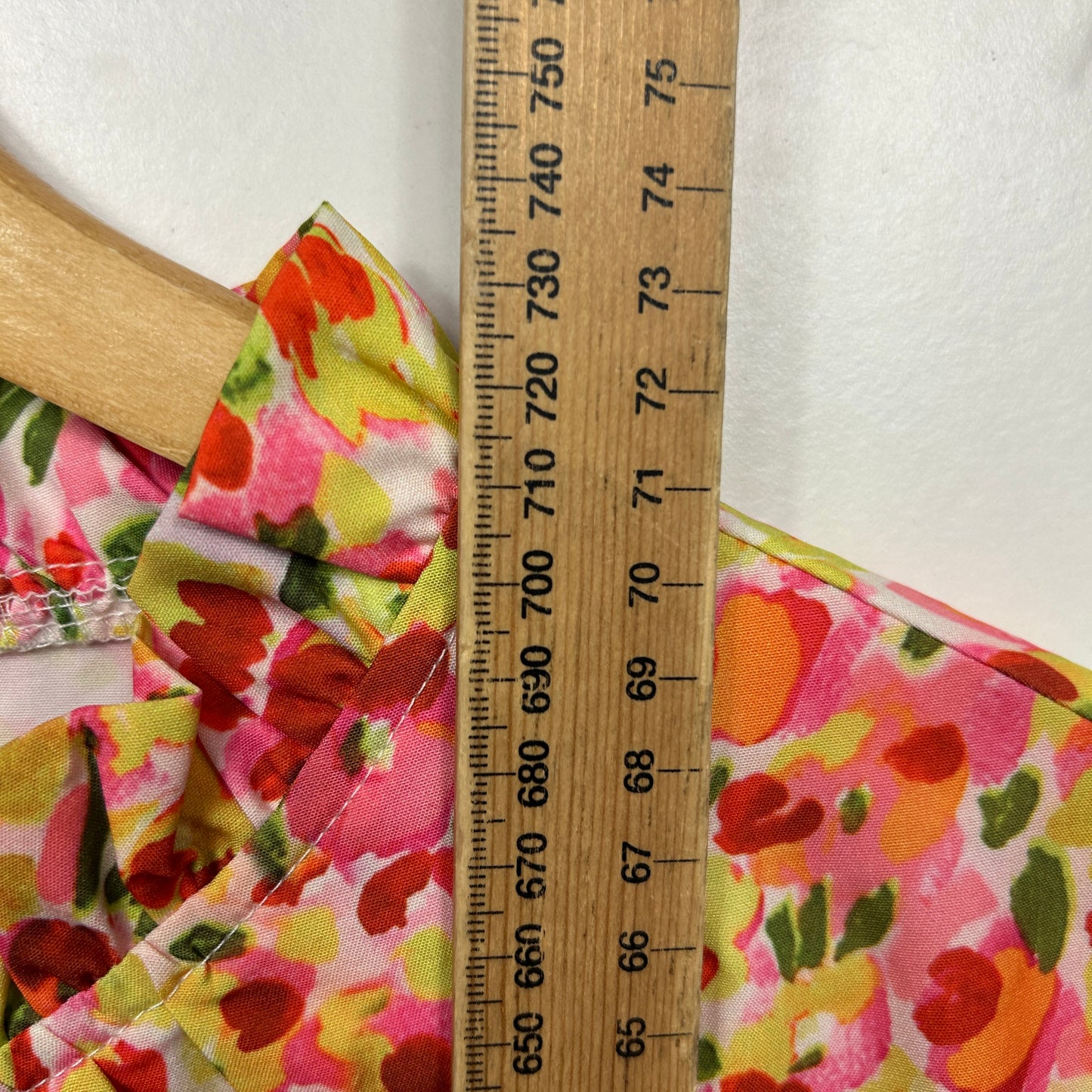 Pink floral print top detail view with ruler