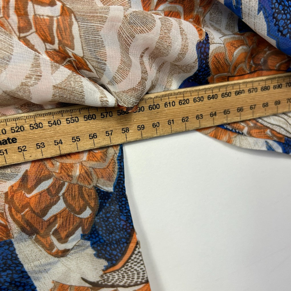 Orange and blue floral fabric detail view with measuring tape