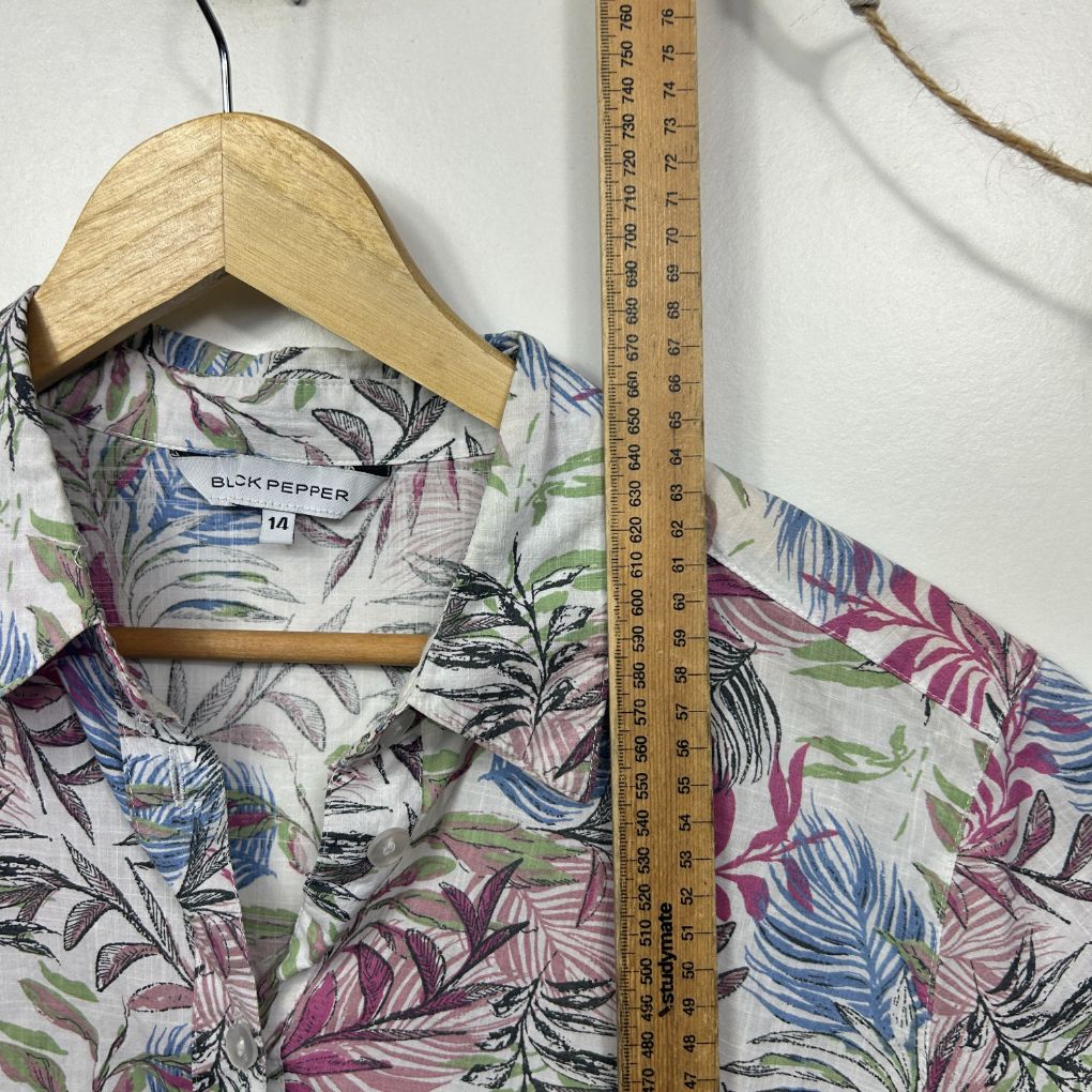 Multicoloured floral shirt front view on wooden hanger with measuring tape