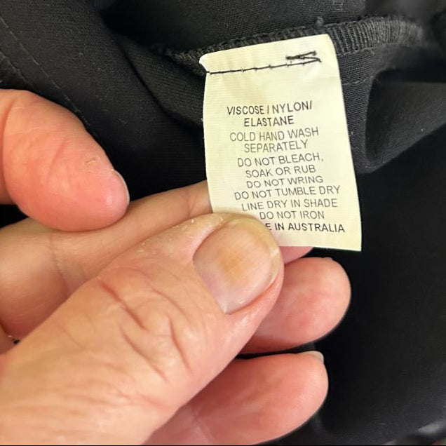 Black garment care label detail view