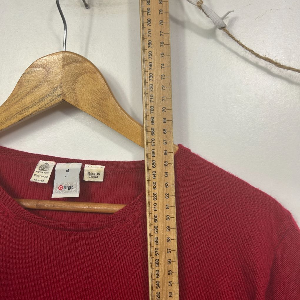 Red sweater front view on wooden hanger with measuring tape