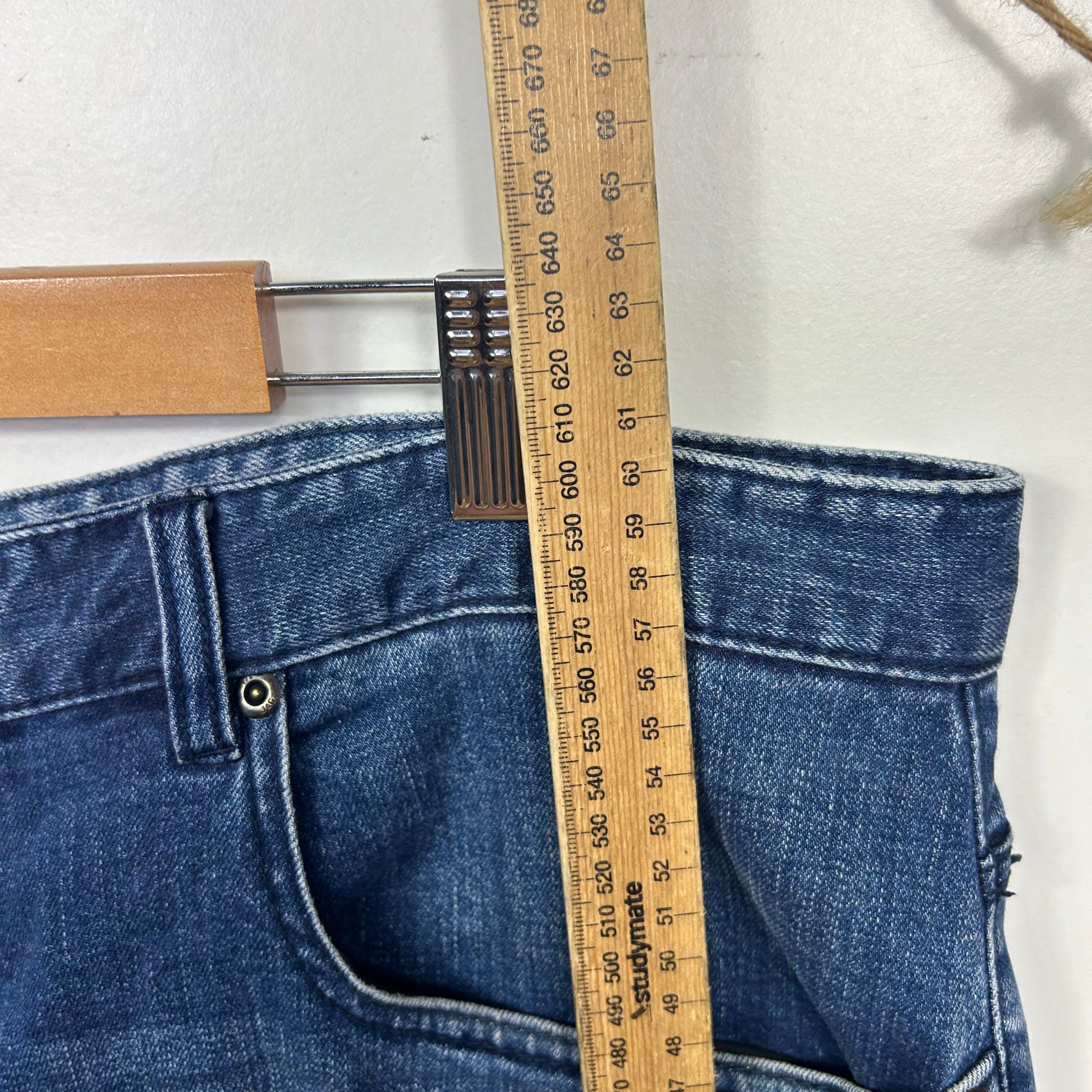 Blue denim jeans front view with measuring tape