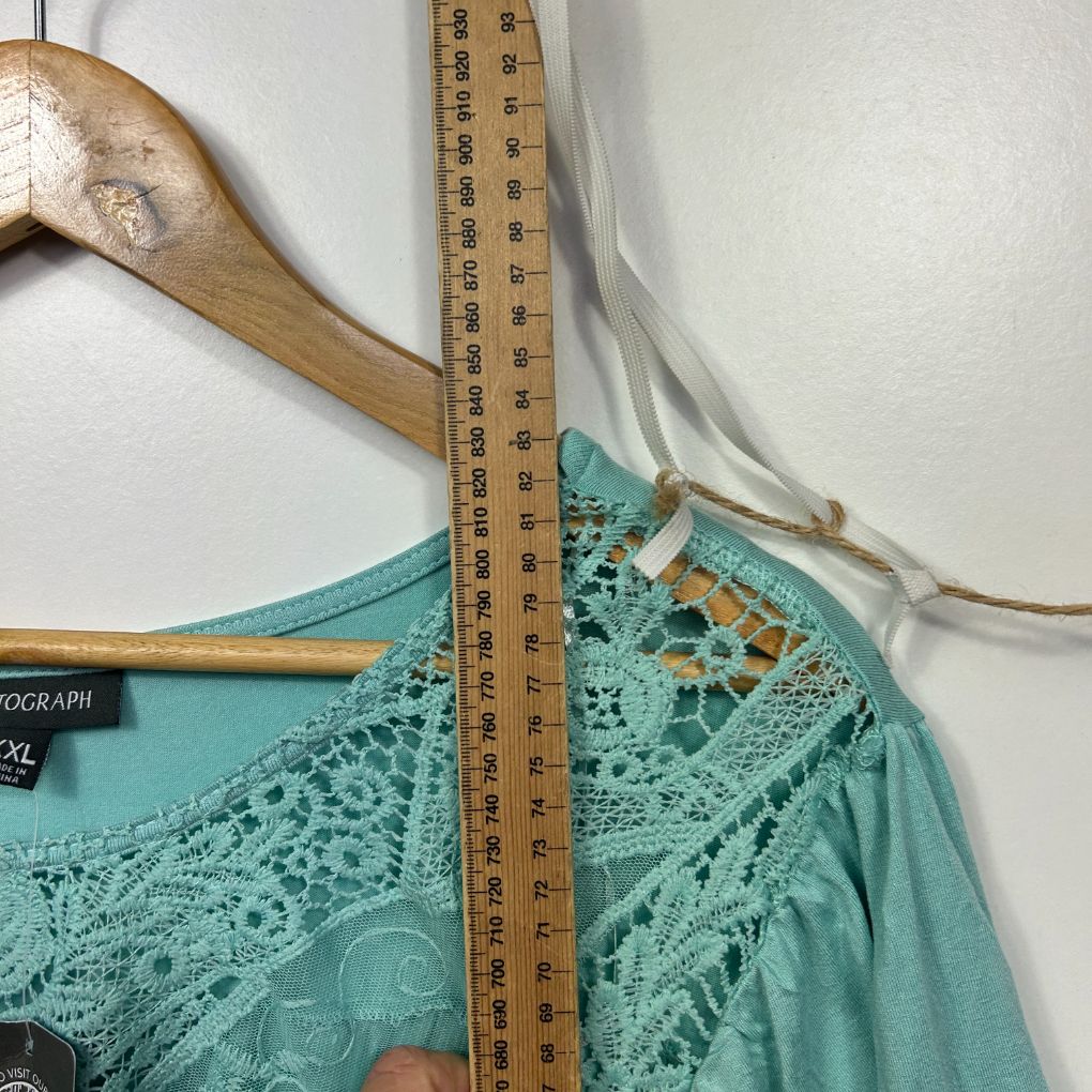 Turquoise lace camisole detail view with wooden hanger and measuring tape