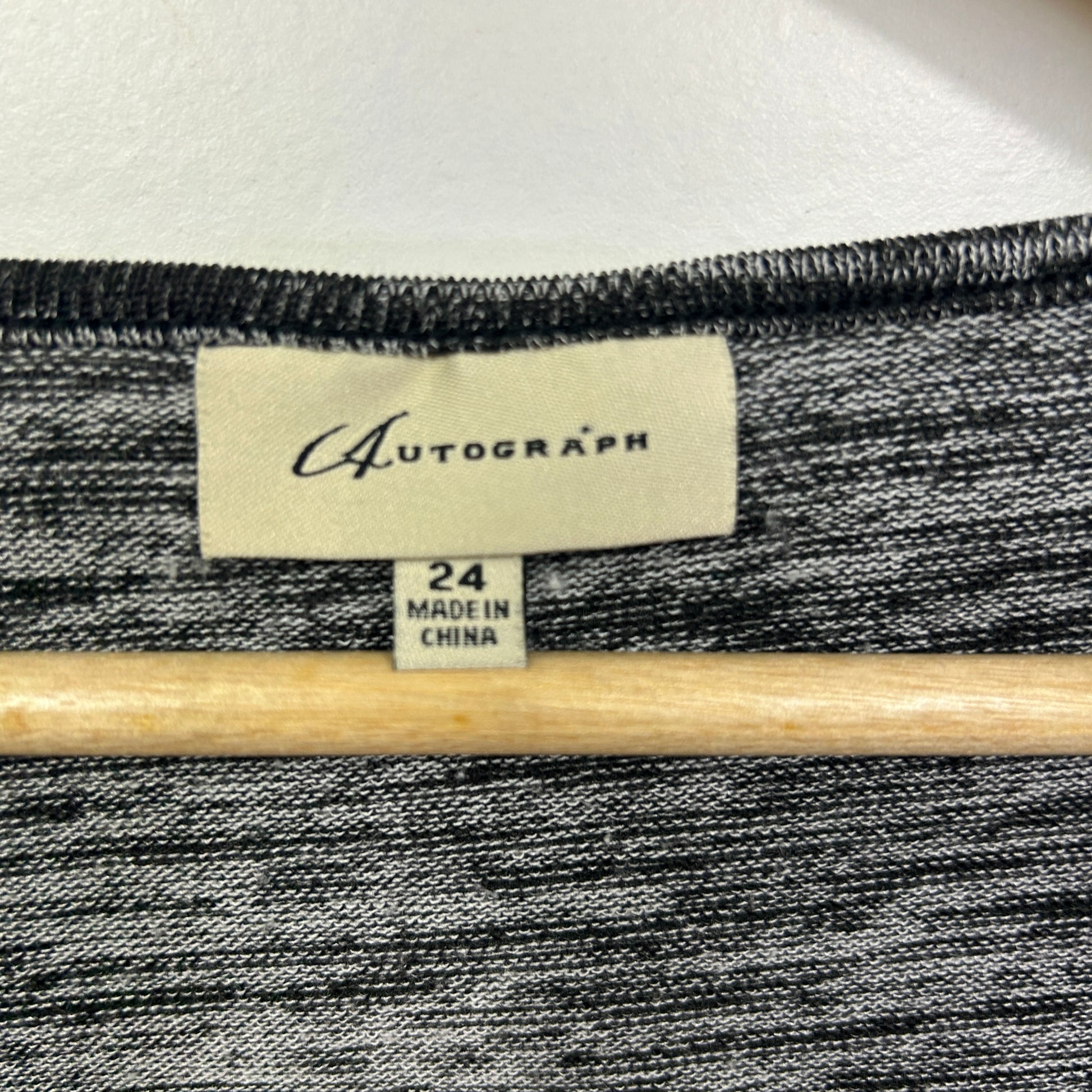 Grey striped knit garment label detail view