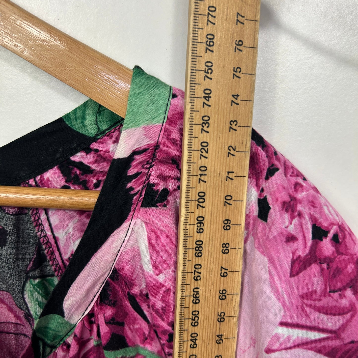Pink floral dress detail view with ruler measurement