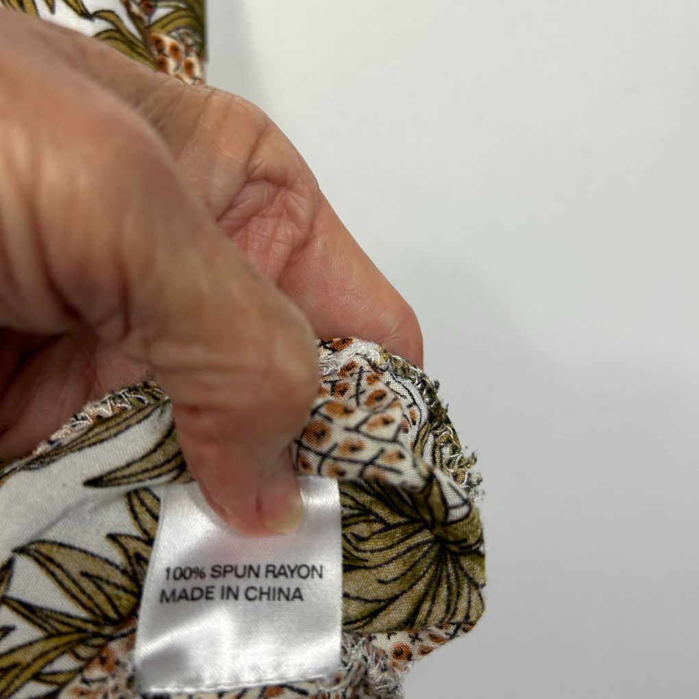Yellow and white floral fabric detail view showing label