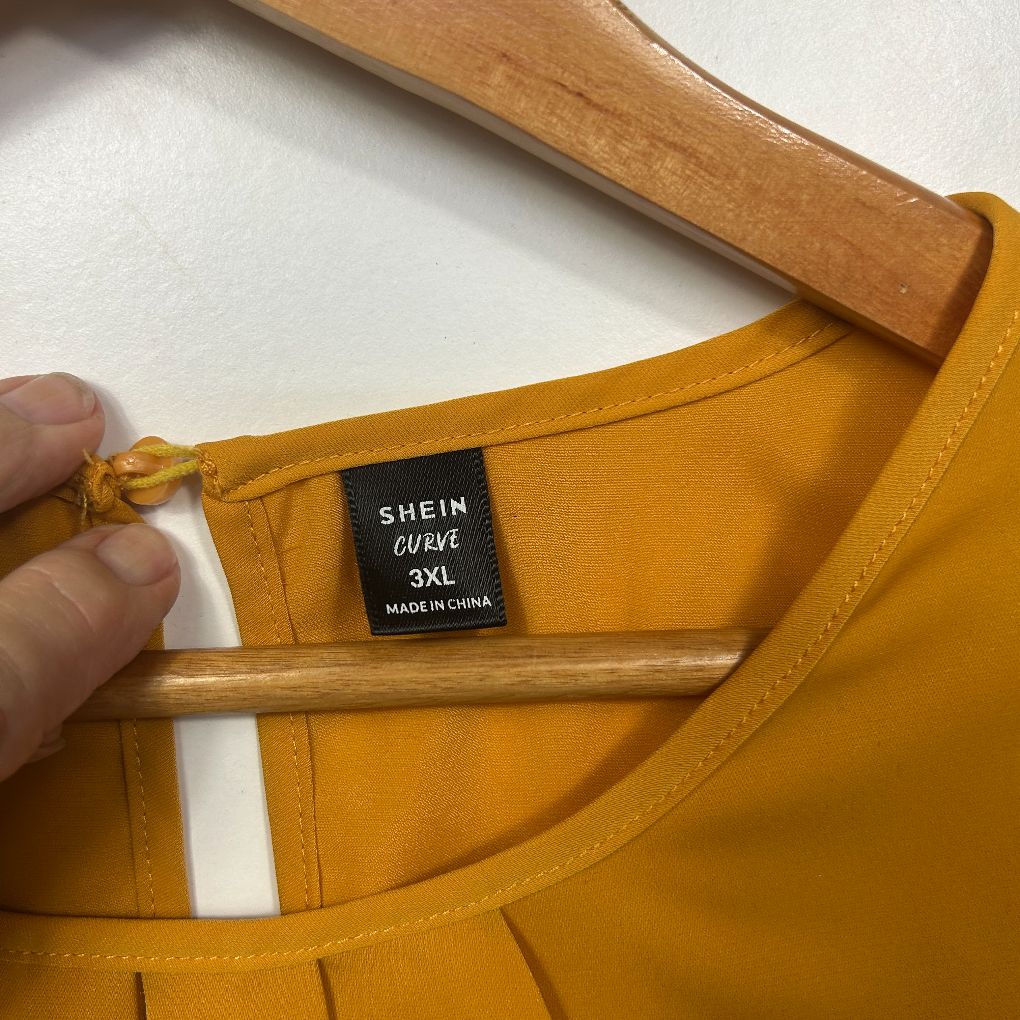 Mustard yellow t-shirt label detail view