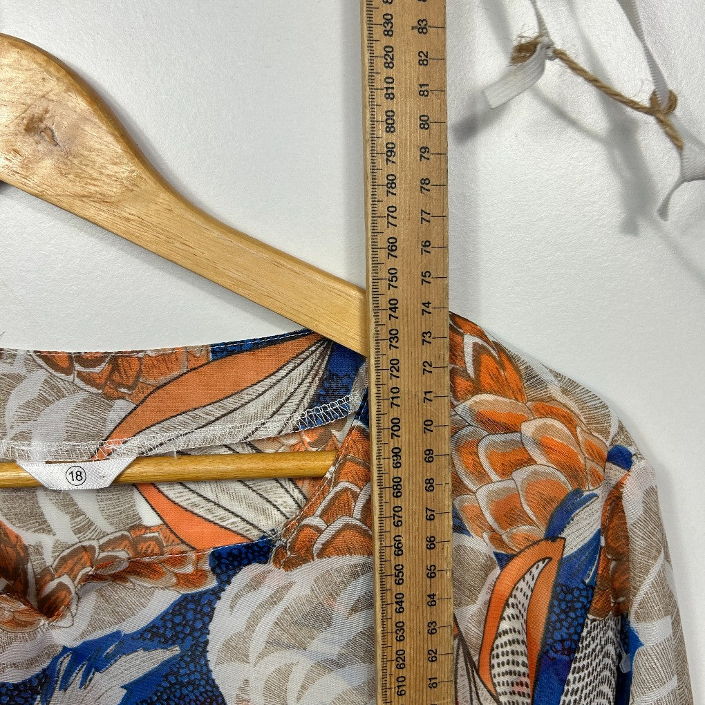 Orange blue and cream floral patterned fabric detail view with wooden hanger and measuring tape